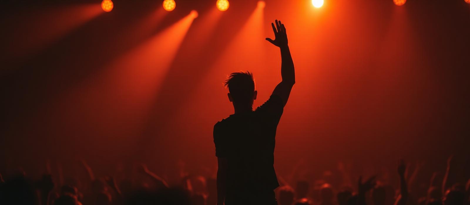 Concert crowd cheering under red stage lights